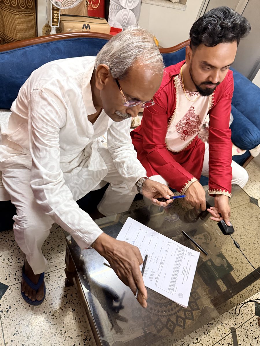 Elder man in white with Shoumo, reviewing documents during the ceremony