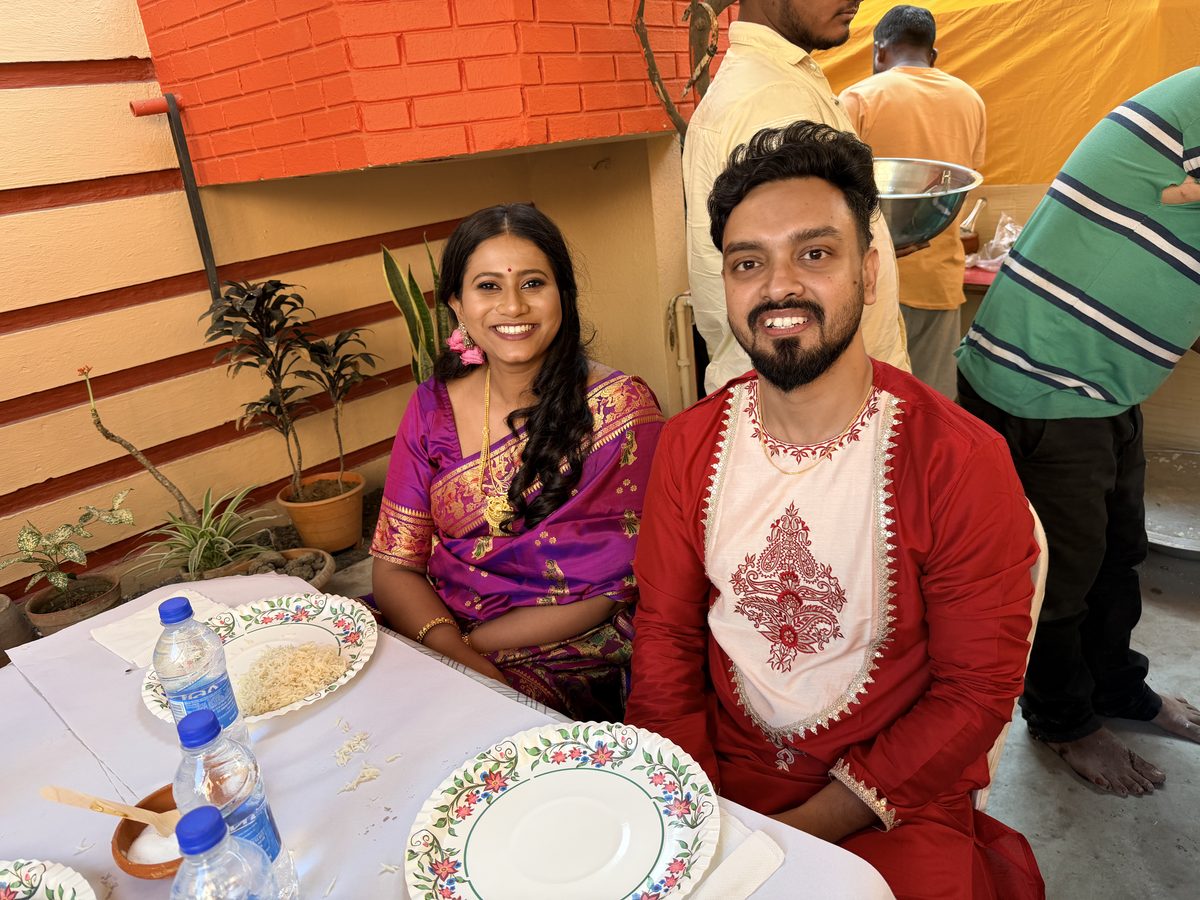Rituparna and Shoumo seated together wearing garlands, joyful moment