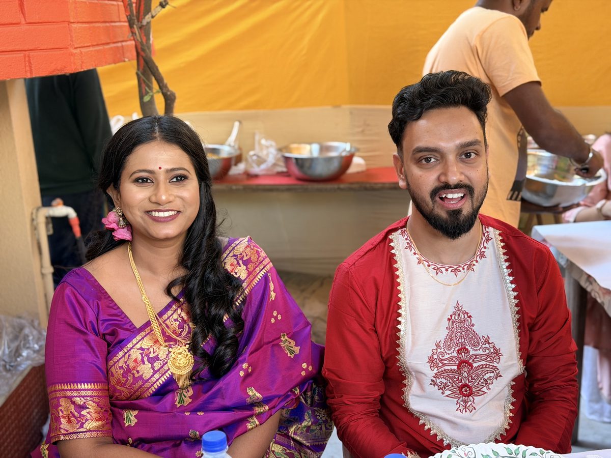 Close-up of Rituparna and Shoumo smiling, bride in purple and groom in red