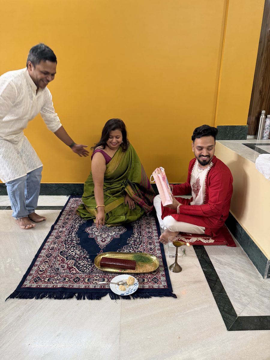 Man in white receiving blessings from woman and Shoumo during ceremony