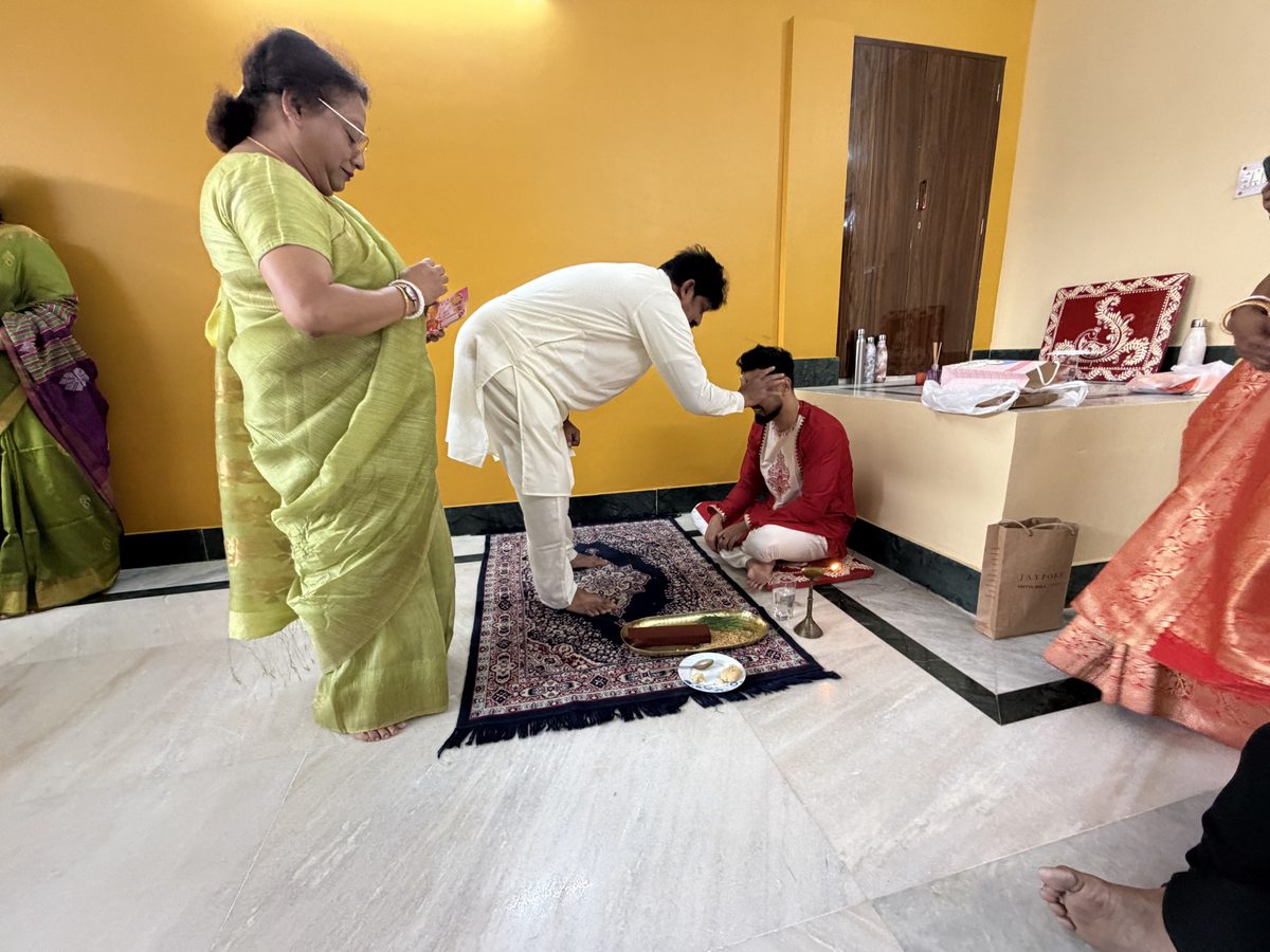 Elder woman and man performing blessings with Shoumo on the prayer mat