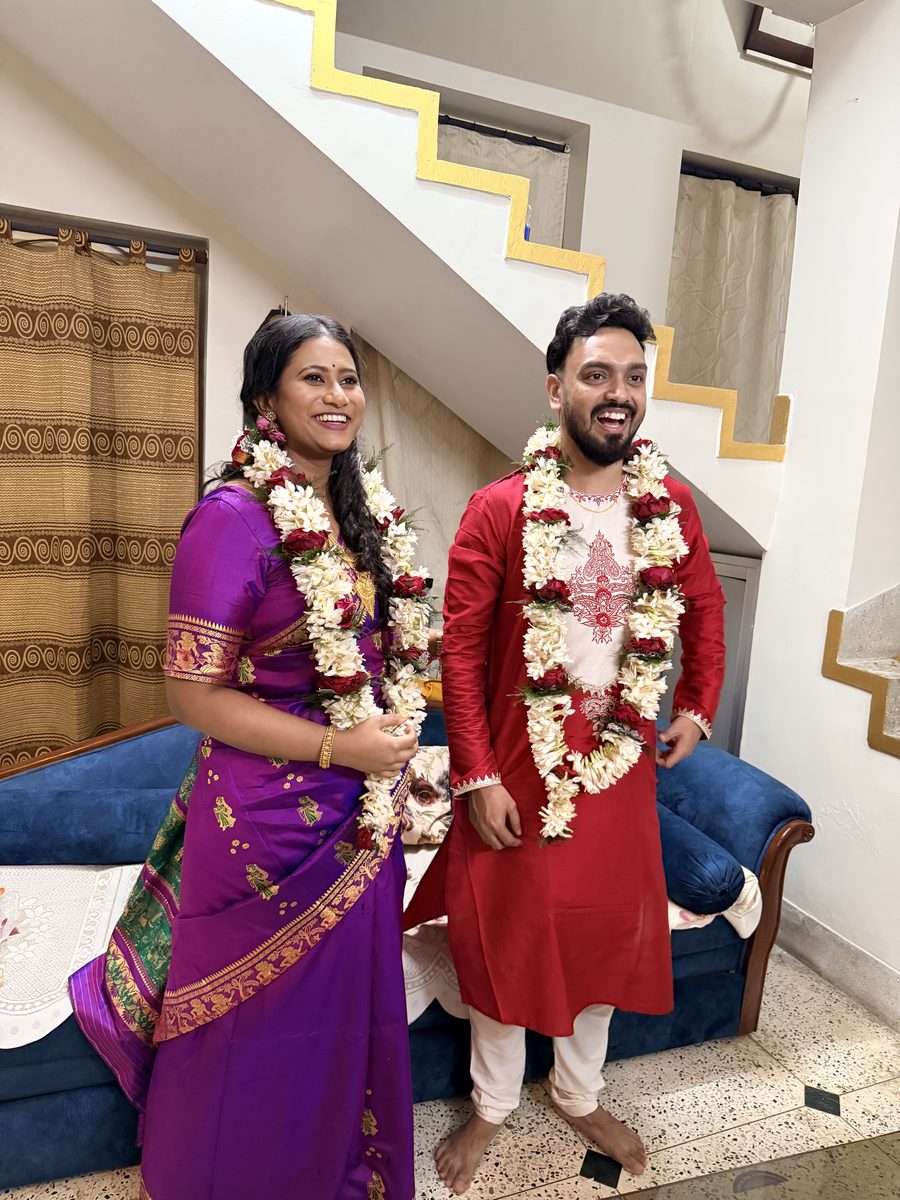 Rituparna & Shoumo standing together with garlands, beaming with joy