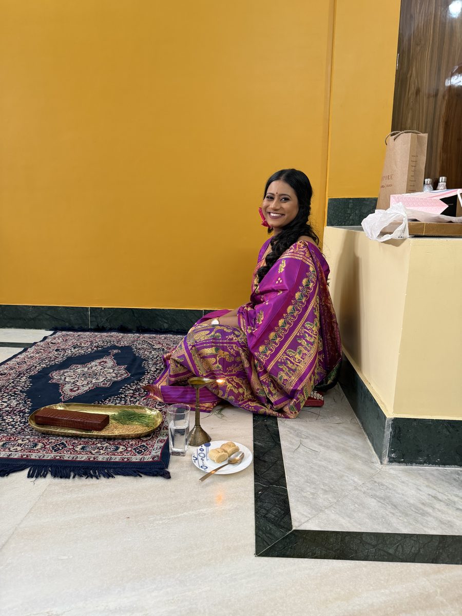 Rituparna in her purple Banarasi smiling at the camera during the ceremony