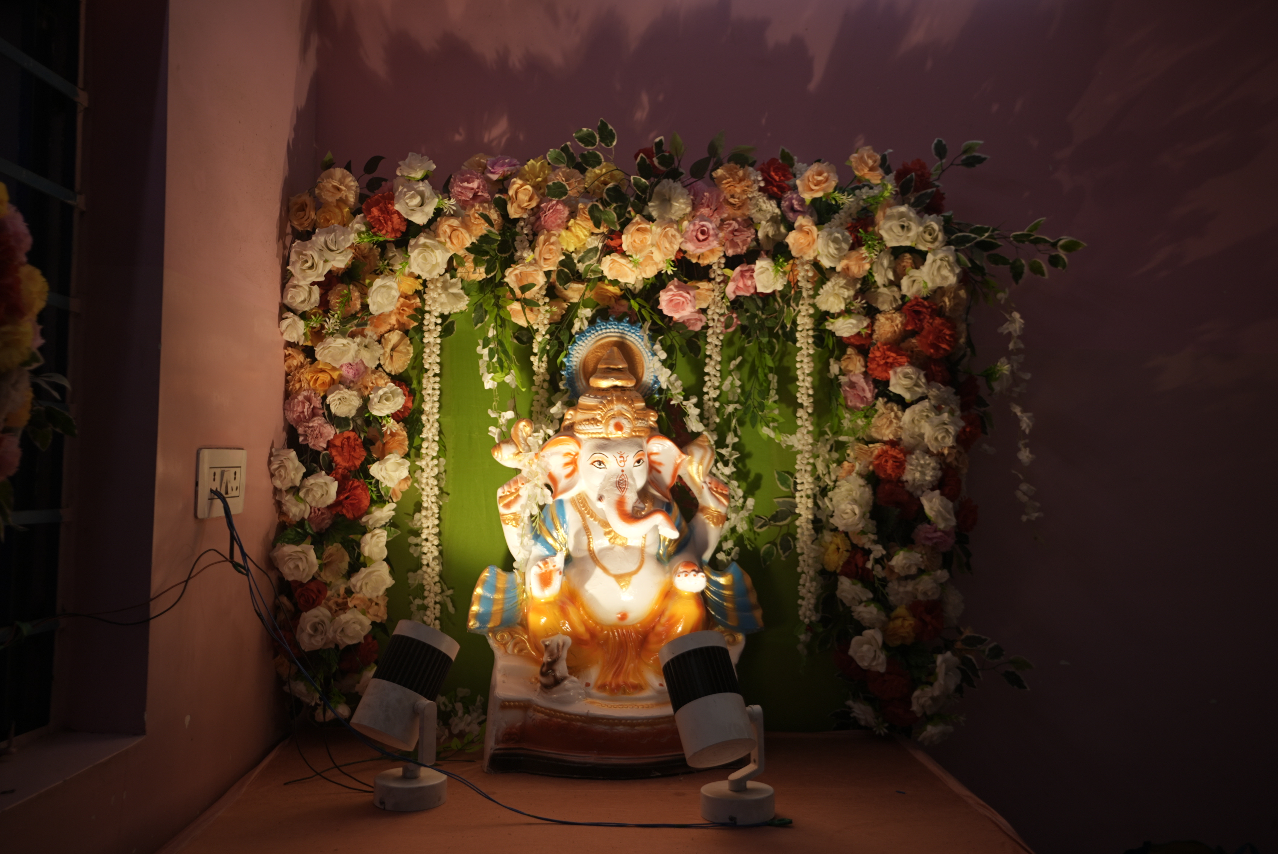 Beautifully decorated Ganesh idol surrounded by fresh flowers and warm lights for the Bhaath-Kapod ceremony