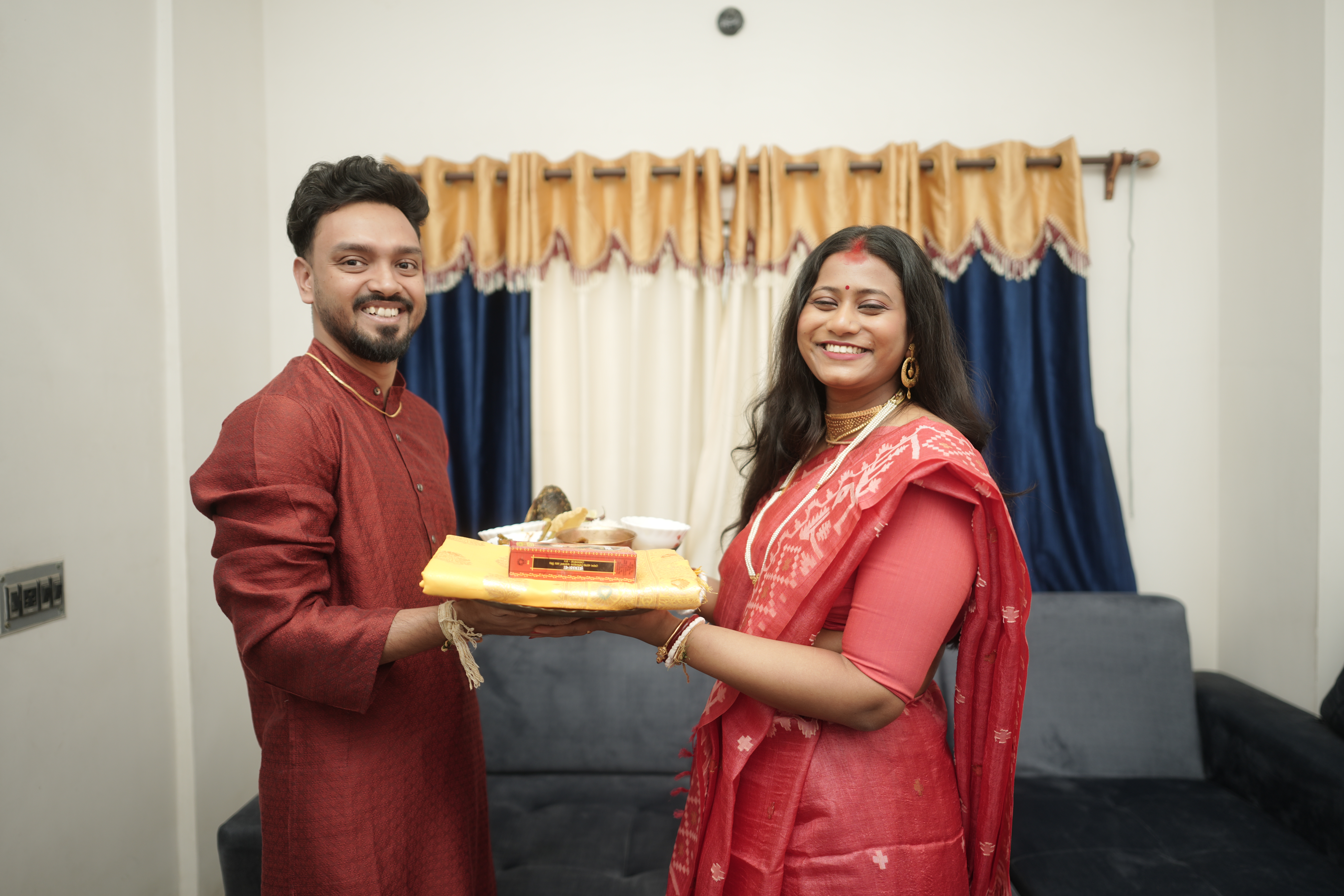 Rituparna and Shoumo holding the gifts together, beaming with happiness