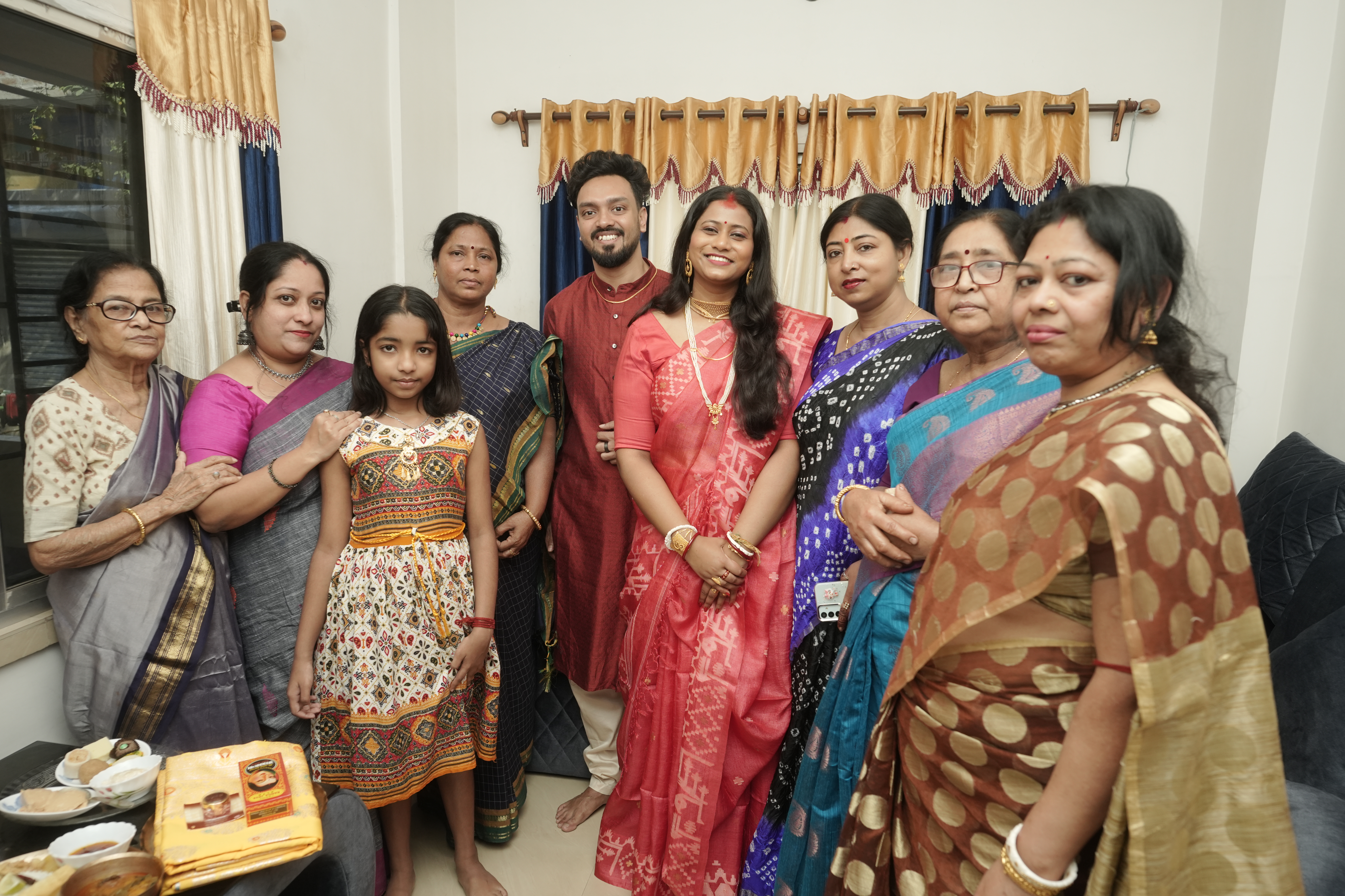 Family group photo with Rituparna and Shoumo surrounded by women of the family in colourful saris