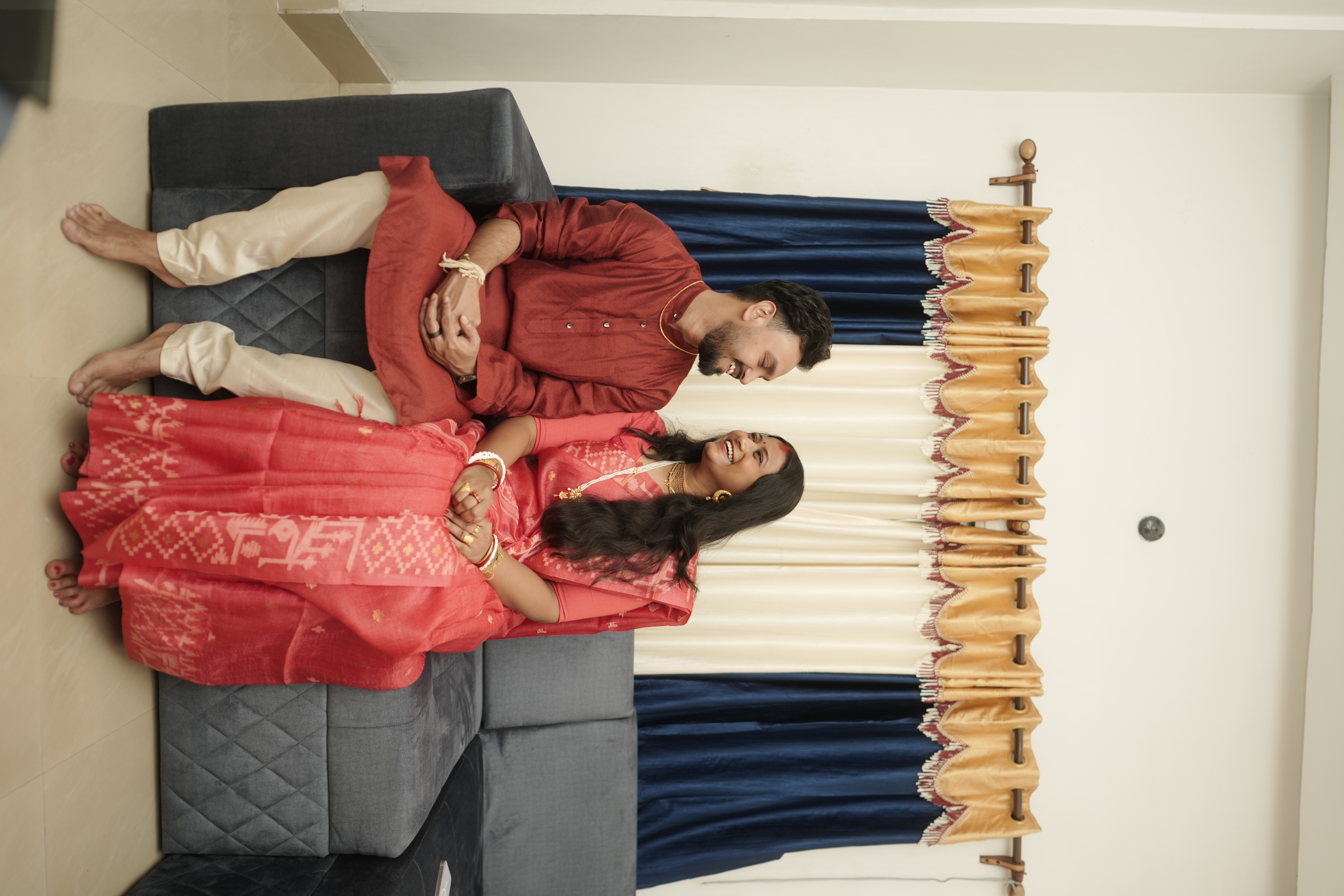 Rituparna and Shoumo reclining on the couch together in a candid, intimate moment