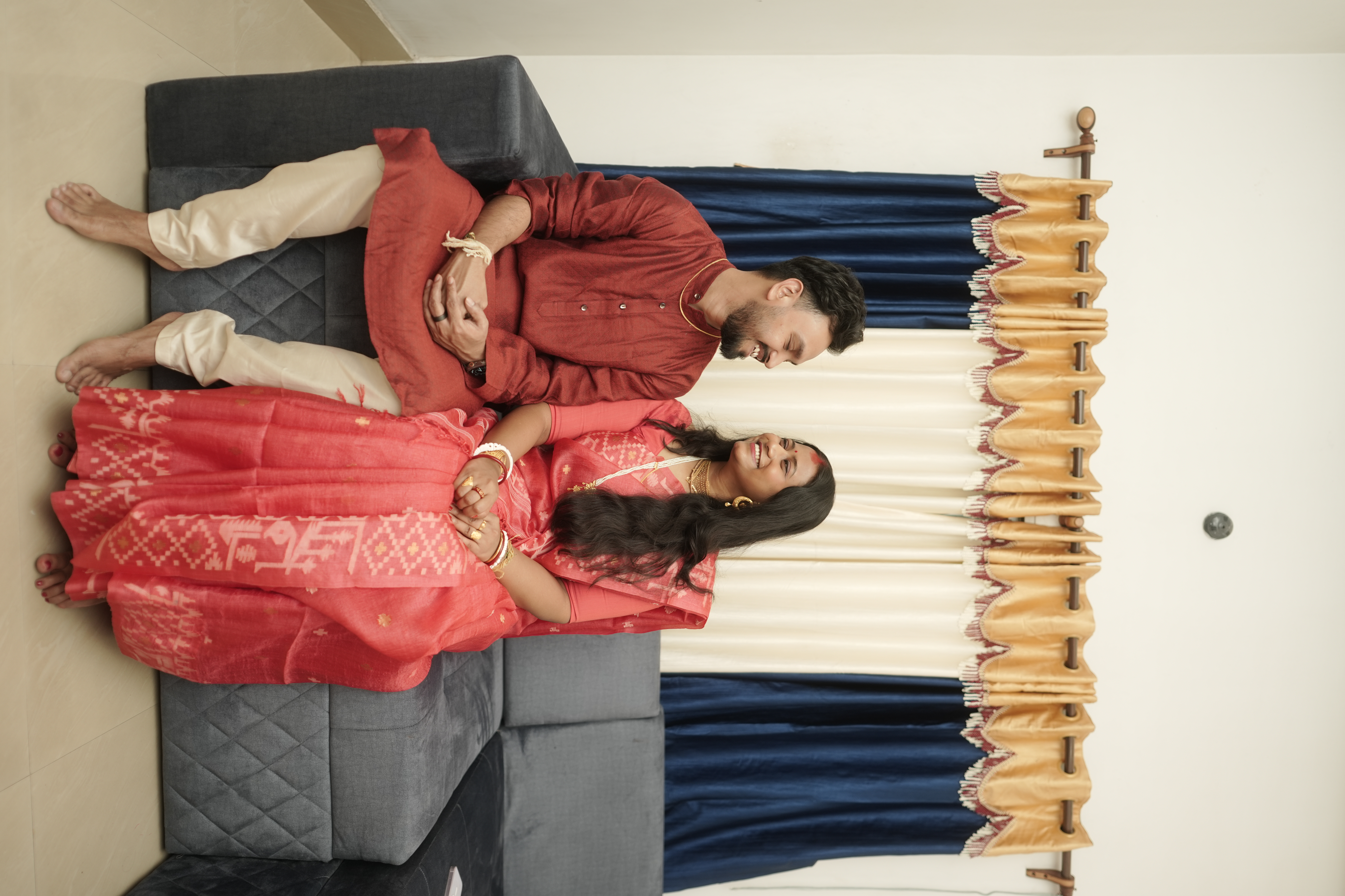 Overhead view of Rituparna and Shoumo reclining together, a tender and intimate portrait