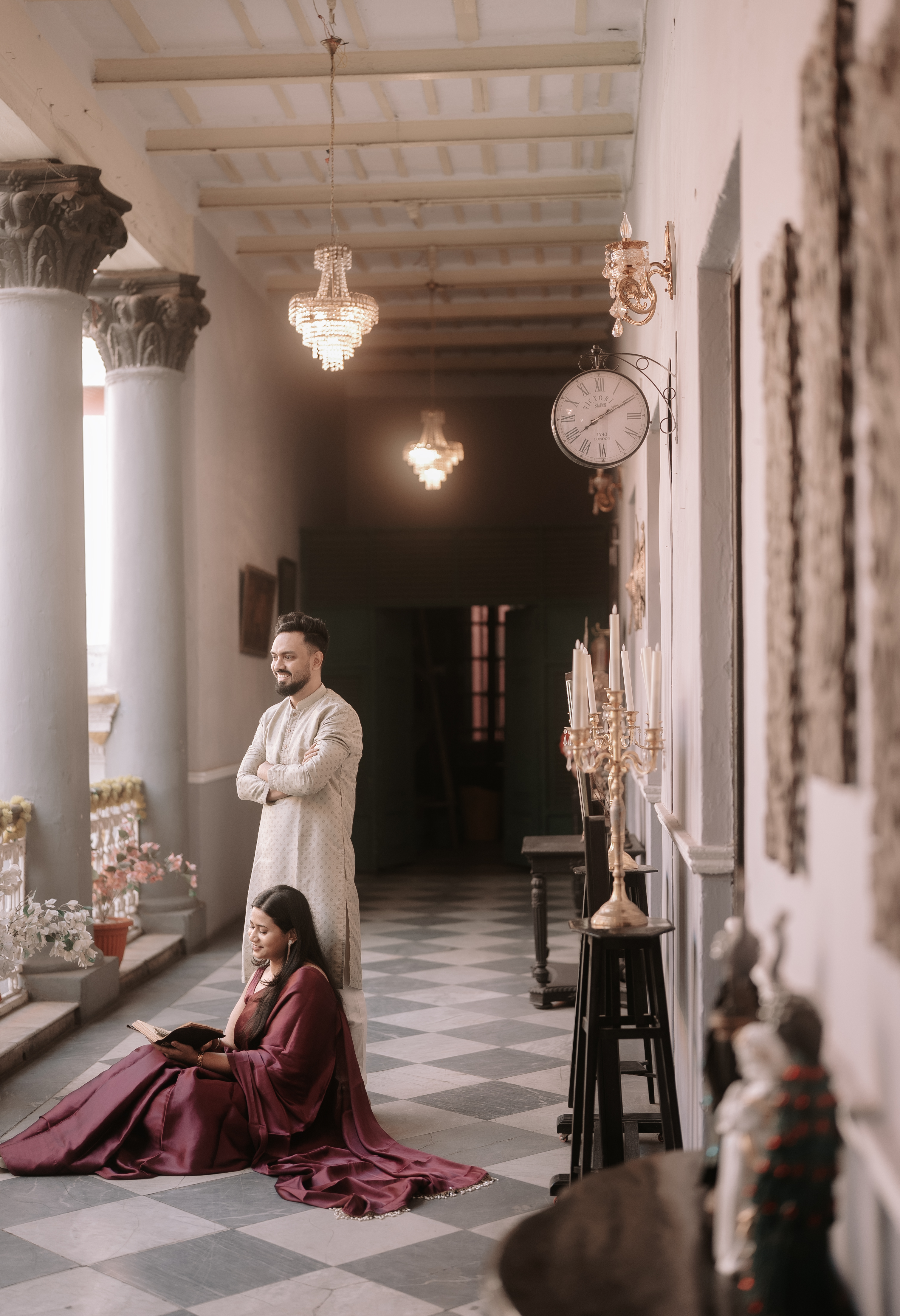 Wide view of an ornate heritage haveli corridor with arched doorways and warm light