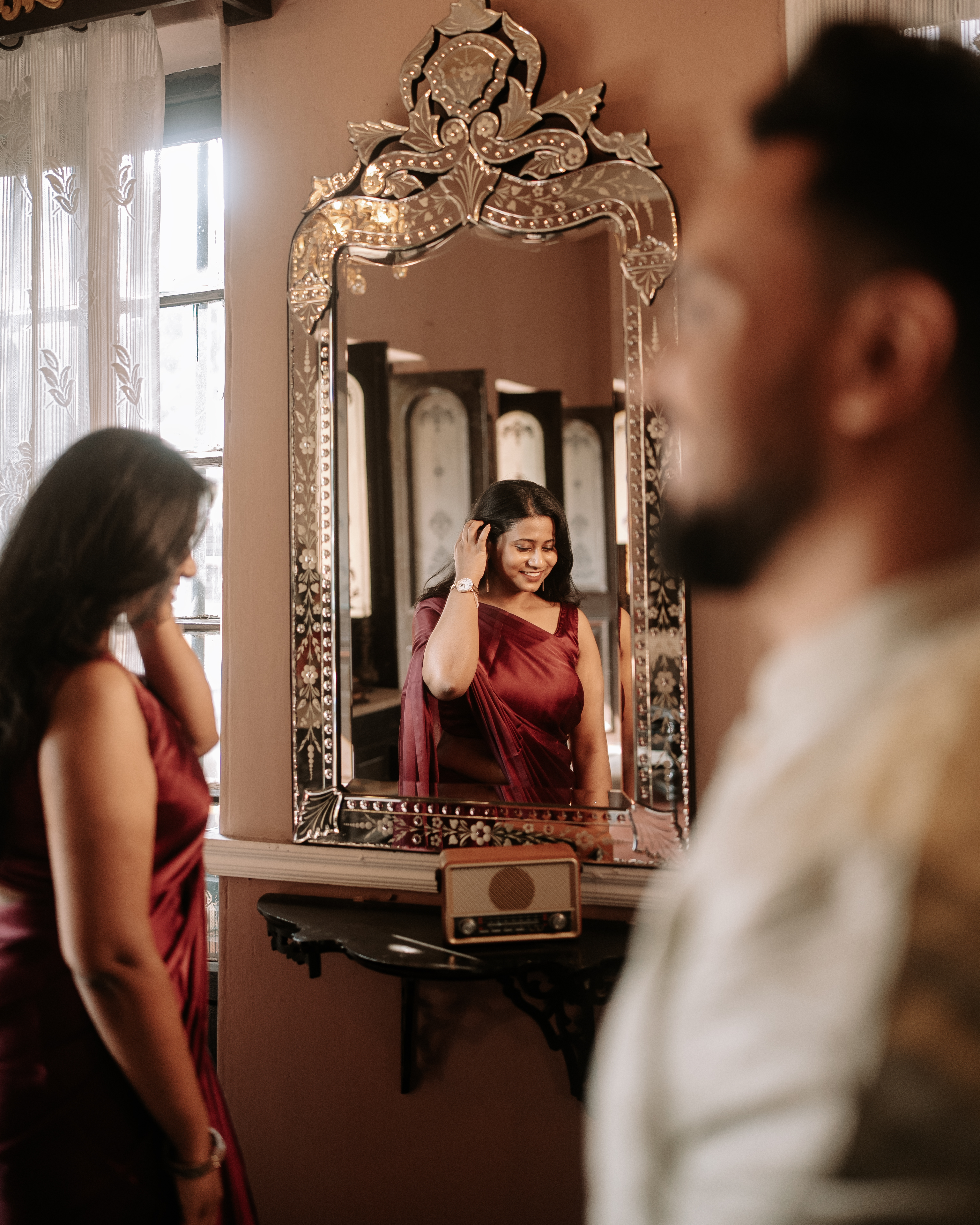 Rituparna adjusting her hair in a mirror reflection, a candid moment of preparation