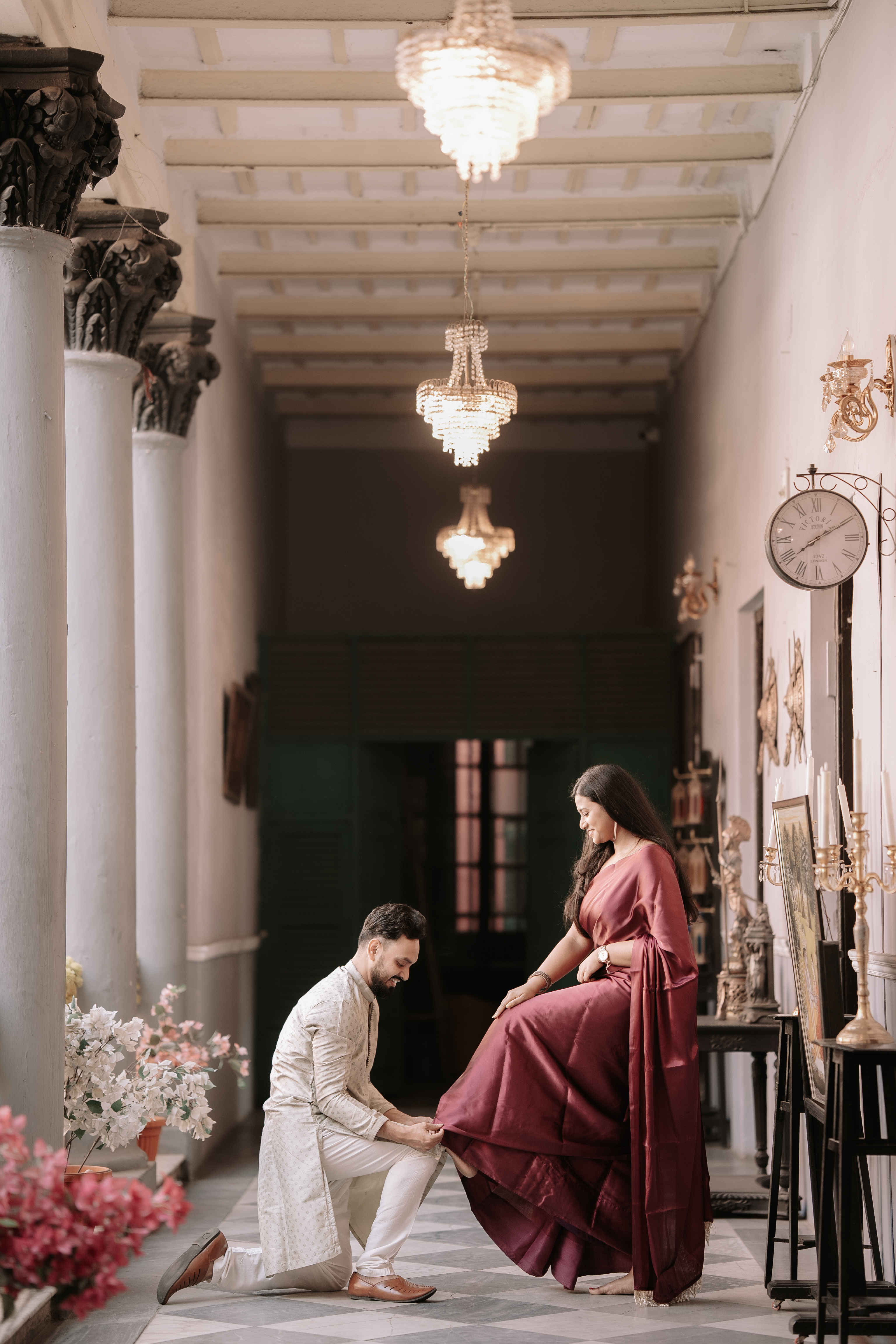 Shoumo kneeling in the haveli corridor in a chivalrous, cinematic pose