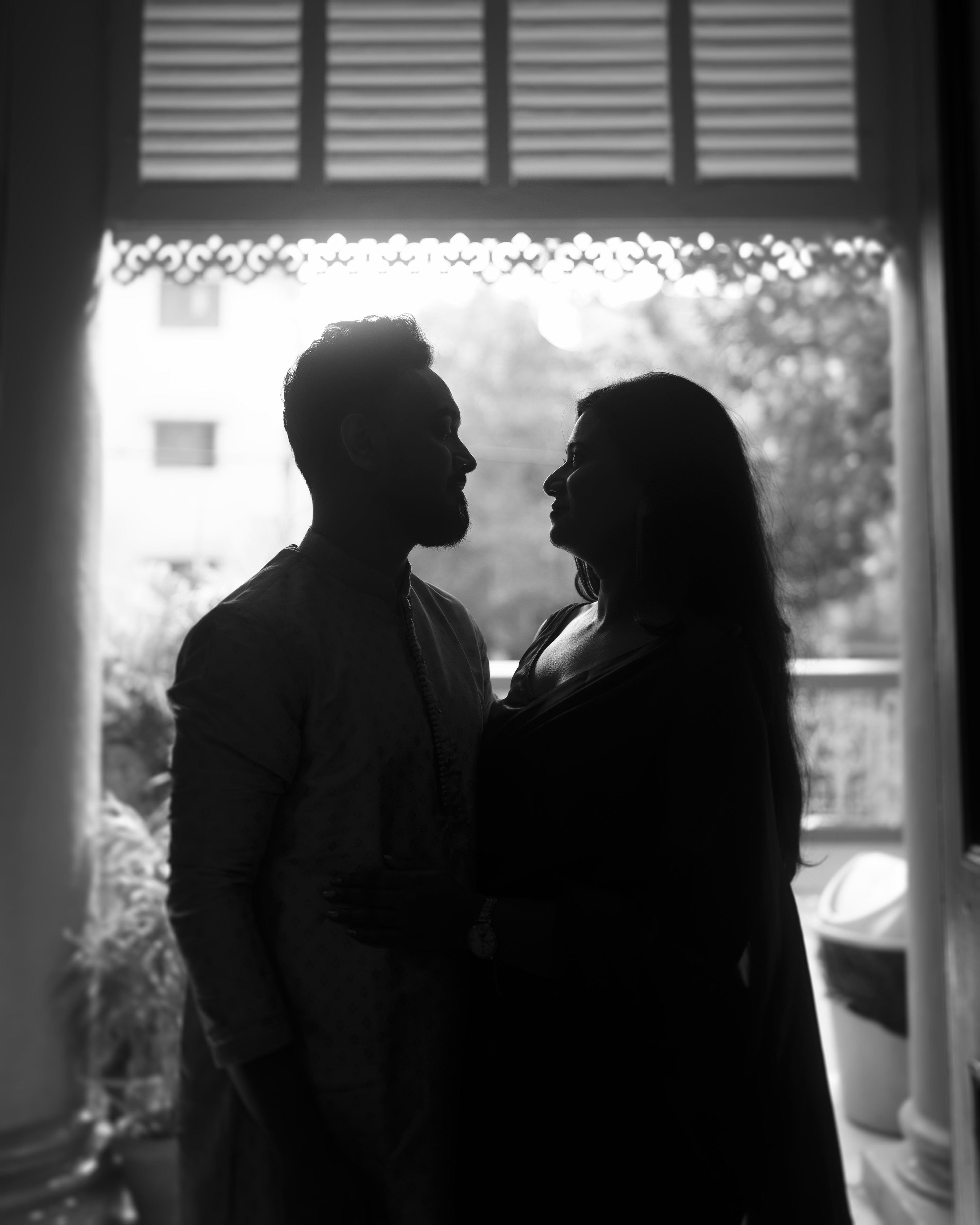 Dramatic window silhouette of the couple in black and white