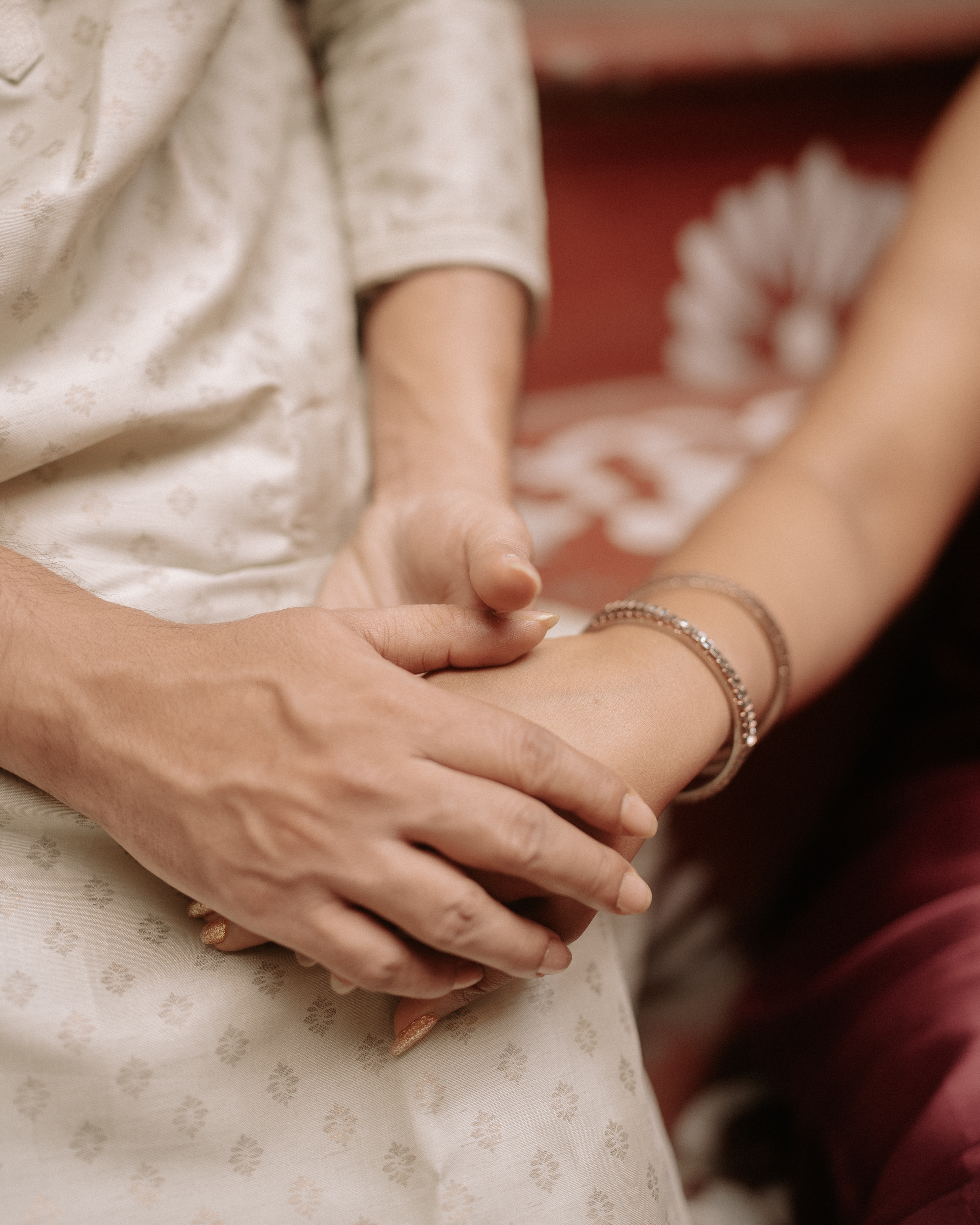 Detail shot of clasped hands resting on the lotus-carved palace steps