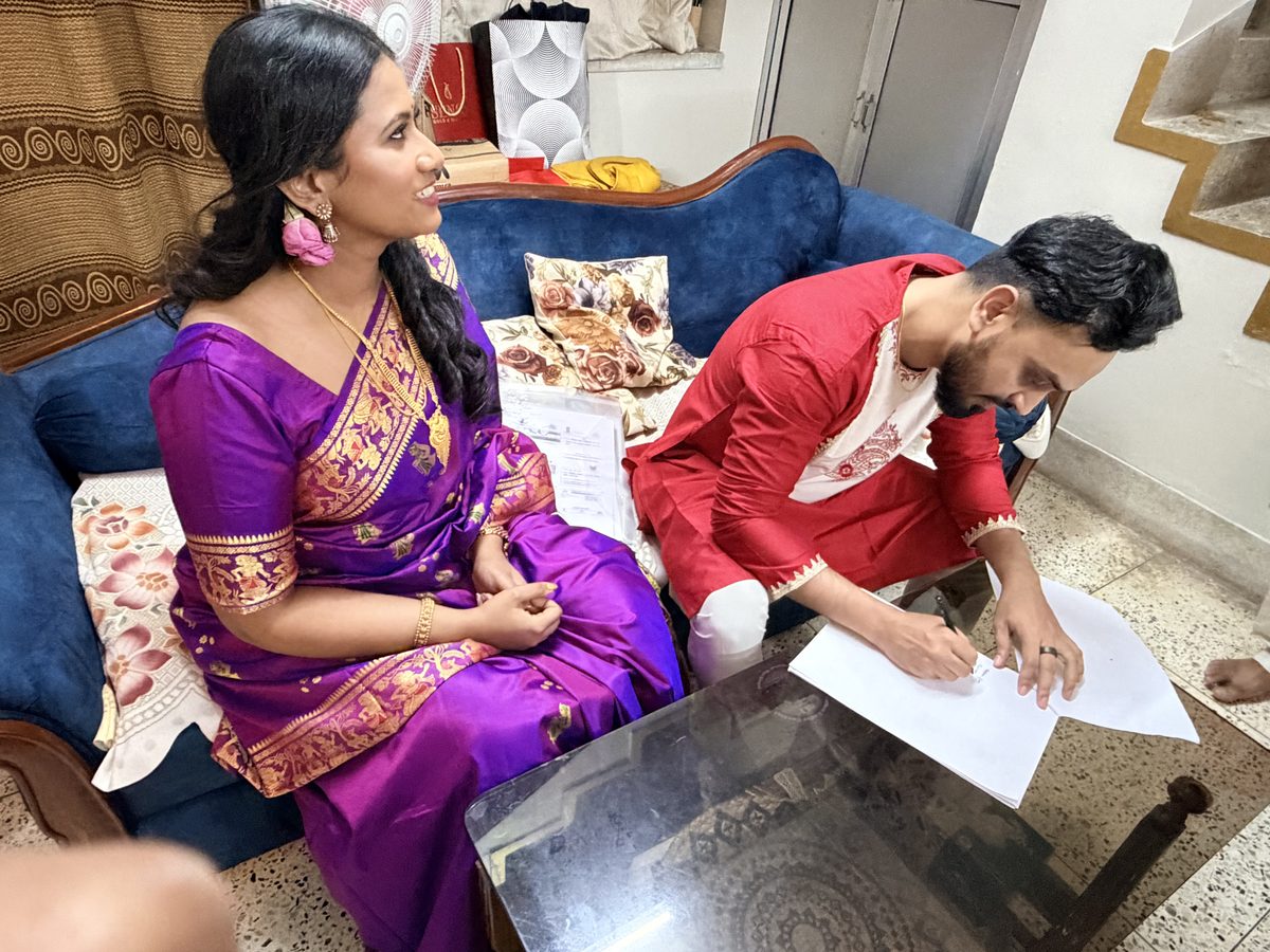 Rituparna and Shoumo signing documents together during the ceremony